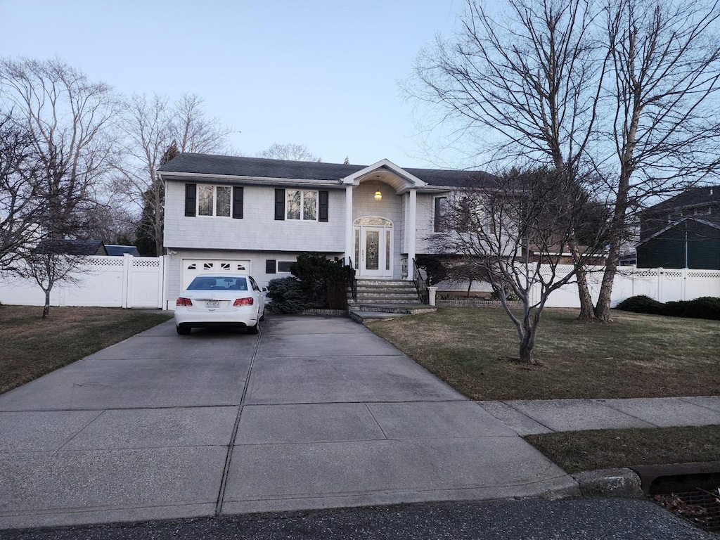 raised ranch with a garage and a front yard