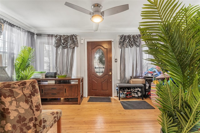 entrance foyer featuring hardwood / wood-style floors, ceiling fan, and crown molding