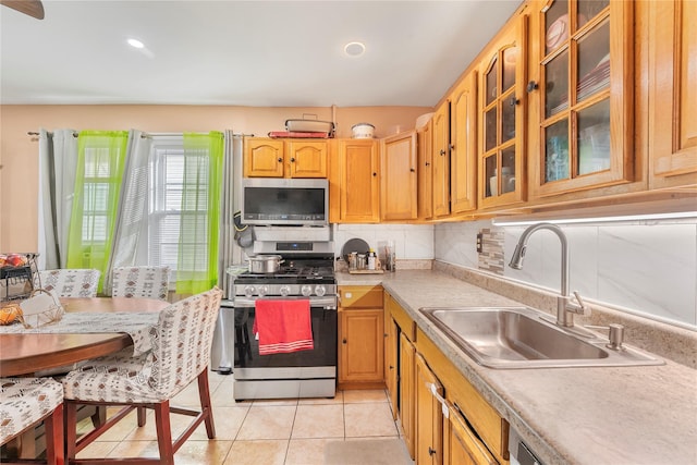 kitchen featuring light tile patterned floors, sink, appliances with stainless steel finishes, and tasteful backsplash