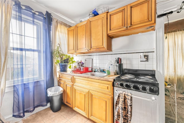 kitchen featuring tasteful backsplash, electric stove, sink, and light tile patterned flooring