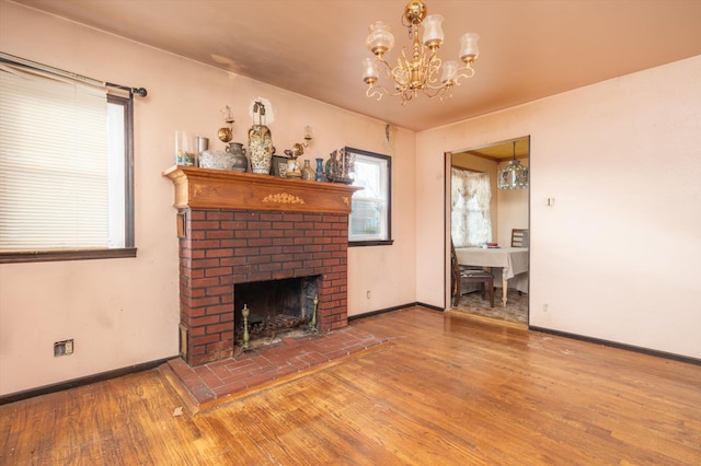 living room with hardwood / wood-style flooring, a fireplace, and an inviting chandelier