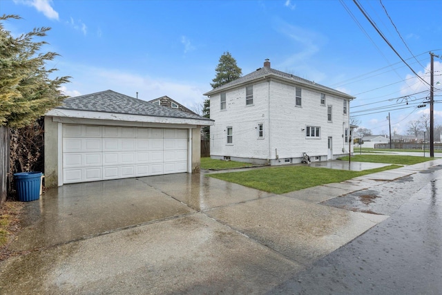 view of property exterior featuring a garage, an outbuilding, and a yard