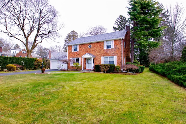 colonial house with a front yard and a garage