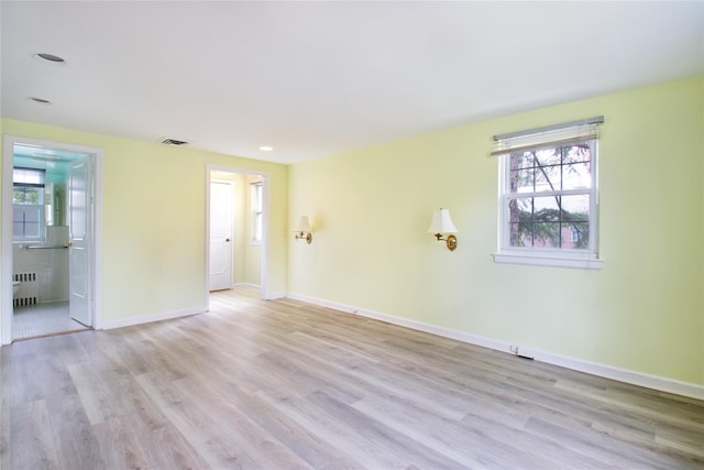 empty room featuring radiator and light wood-type flooring