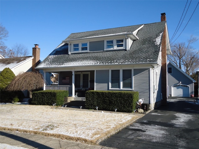 view of front of property with a garage, an outdoor structure, and a porch