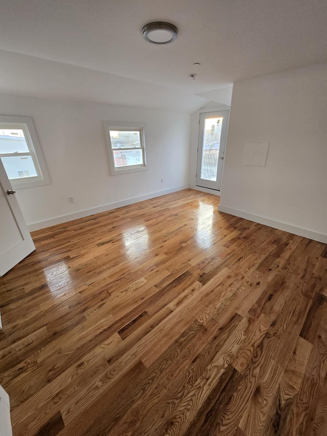 spare room featuring light hardwood / wood-style flooring and vaulted ceiling