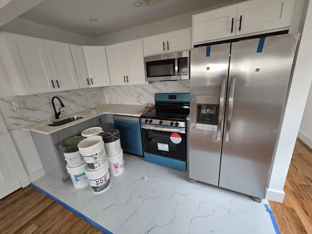 kitchen with white cabinets, appliances with stainless steel finishes, decorative backsplash, and sink