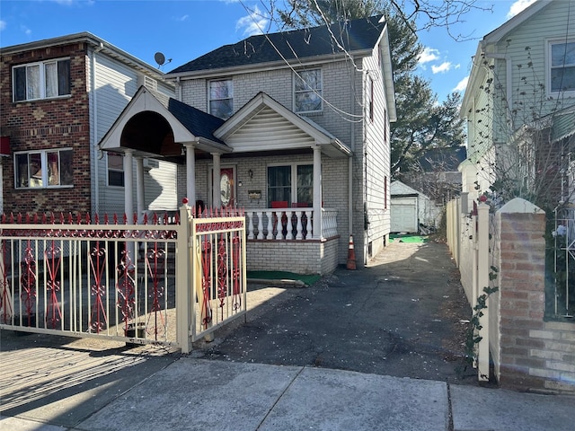 view of front of property featuring a porch, brick siding, and fence