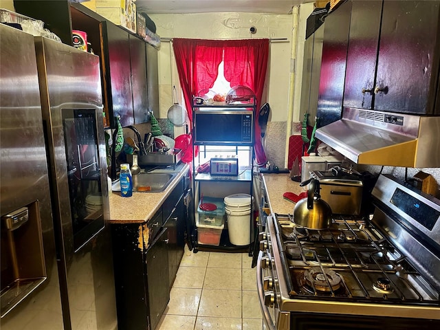 kitchen featuring light tile patterned floors, stainless steel appliances, and range hood