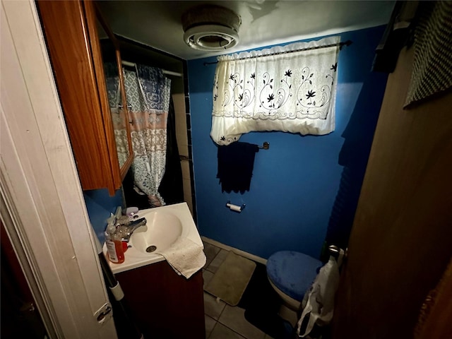 bathroom with toilet, tile patterned flooring, and vanity