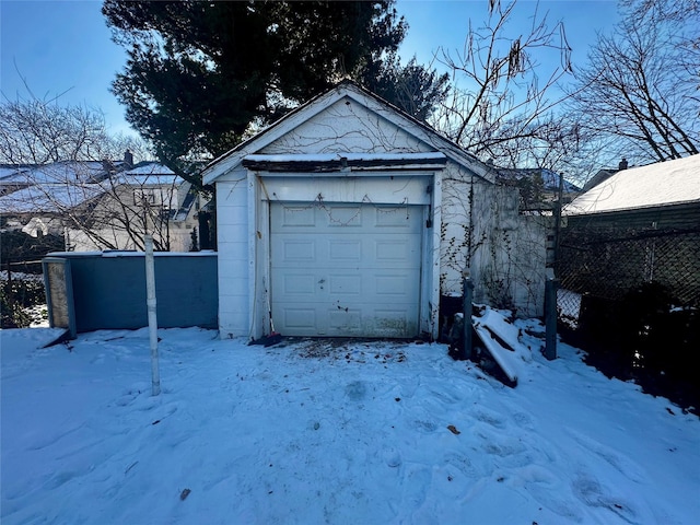 snow covered garage featuring a garage