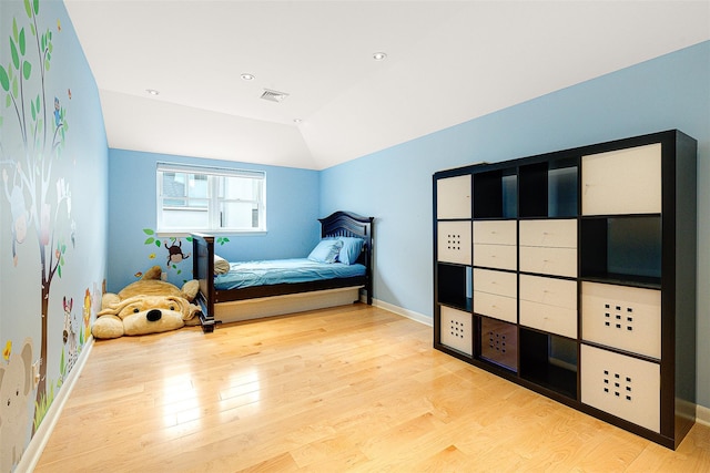 bedroom featuring light hardwood / wood-style flooring and vaulted ceiling