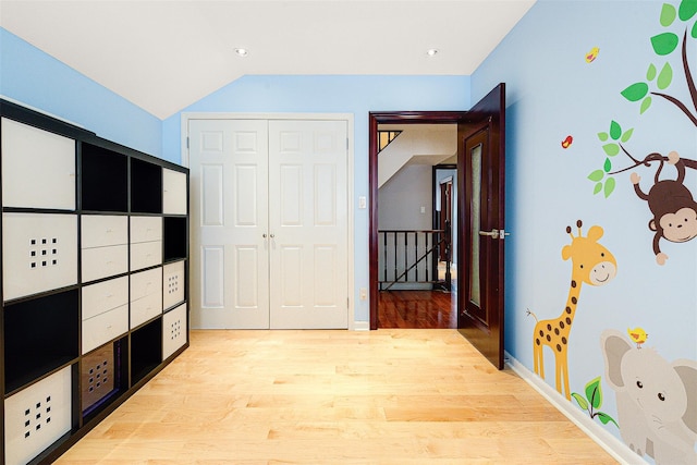 hall featuring light wood-type flooring and lofted ceiling