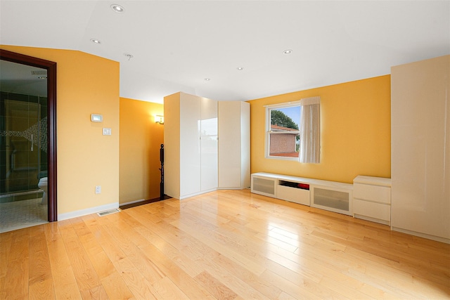 unfurnished room with light hardwood / wood-style floors and vaulted ceiling