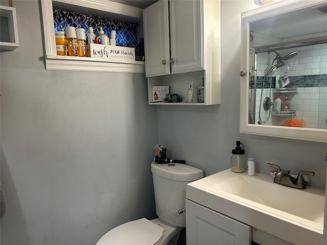 bathroom featuring vanity, toilet, and a shower with shower door