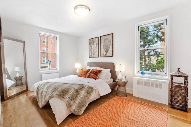 bedroom with radiator and light wood-type flooring