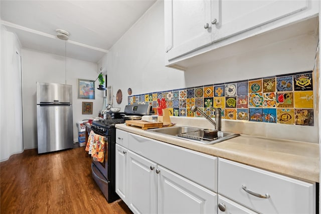 kitchen with backsplash, dark hardwood / wood-style flooring, stainless steel appliances, sink, and white cabinetry