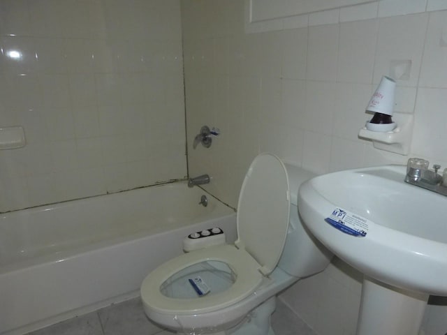 full bathroom featuring tile patterned flooring, sink, tile walls, toilet, and  shower combination