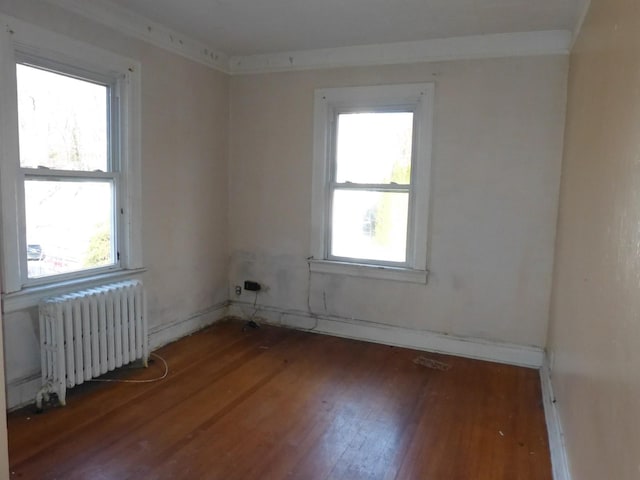 unfurnished room featuring radiator and dark hardwood / wood-style flooring