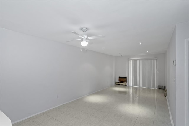 empty room featuring ceiling fan and a baseboard radiator