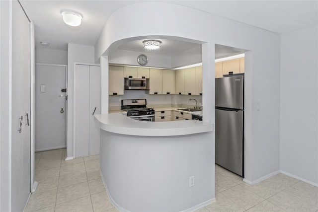 kitchen featuring cream cabinetry, light tile patterned floors, stainless steel appliances, and sink