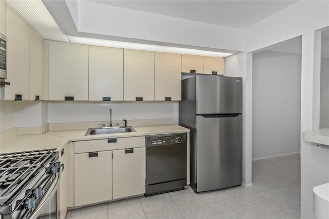 kitchen featuring cream cabinetry, light tile patterned flooring, sink, and stainless steel appliances