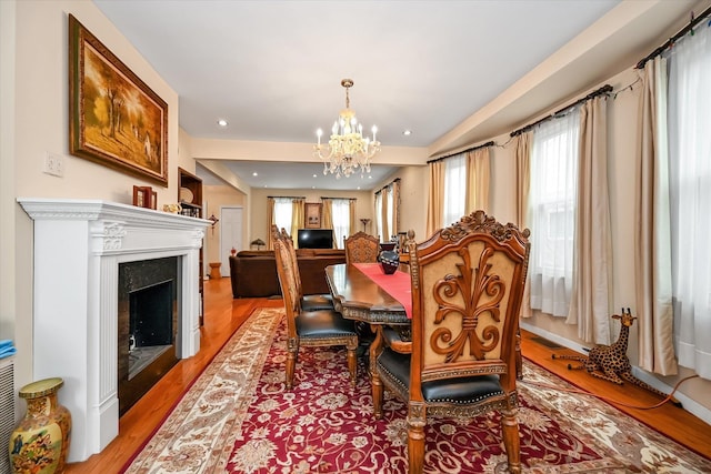 dining space with light hardwood / wood-style floors and a notable chandelier