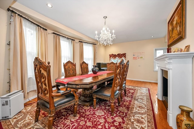 dining area with a healthy amount of sunlight, light wood-type flooring, and a chandelier