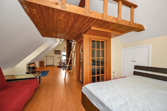 bedroom featuring wooden ceiling, light hardwood / wood-style floors, and lofted ceiling