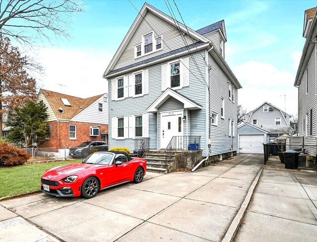 traditional style home featuring a garage, concrete driveway, an outdoor structure, and fence