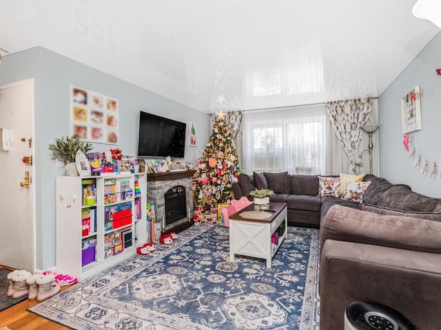 living room featuring a stone fireplace and hardwood / wood-style floors