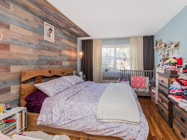 bedroom featuring wood walls and dark hardwood / wood-style flooring