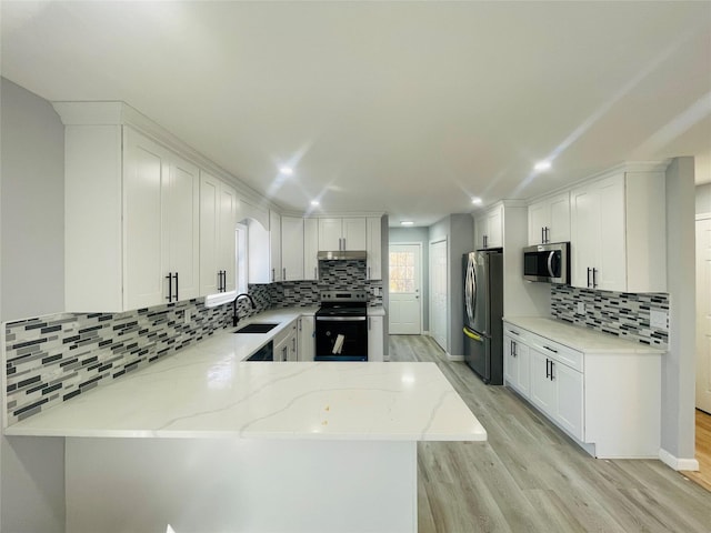 kitchen featuring sink, white cabinetry, kitchen peninsula, stainless steel appliances, and light stone countertops