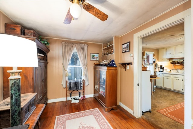 sitting room with hardwood / wood-style floors, ceiling fan, and ornamental molding