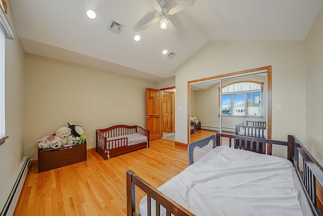 bedroom featuring lofted ceiling, a closet, baseboard heating, and ceiling fan