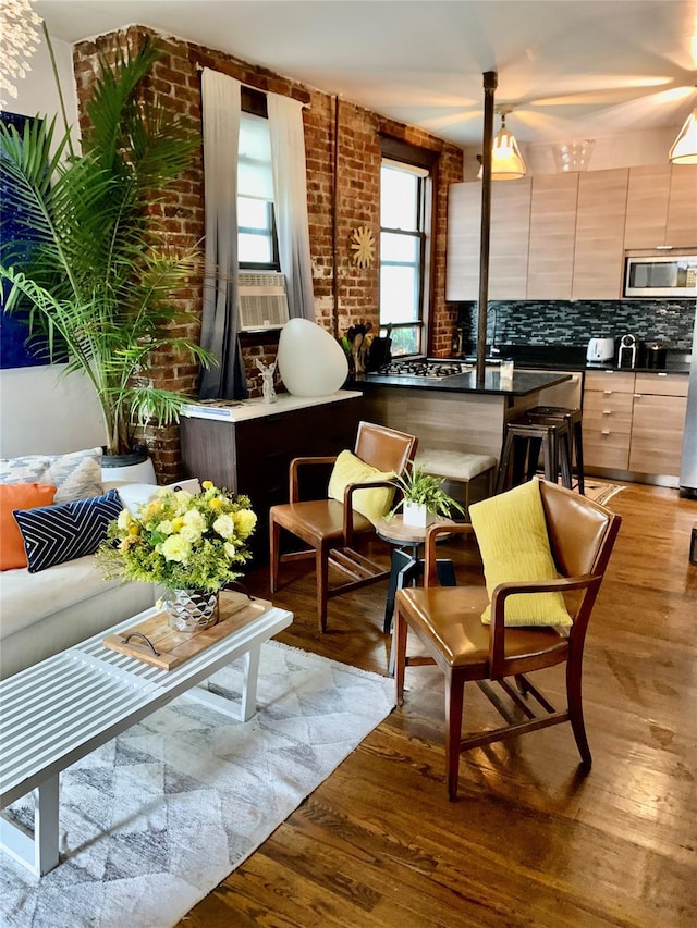 interior space featuring a wealth of natural light, light hardwood / wood-style flooring, and brick wall