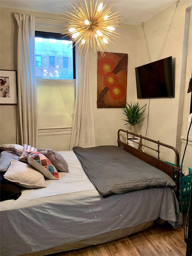 bedroom featuring hardwood / wood-style floors and a notable chandelier