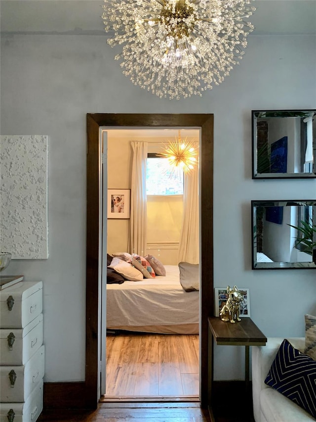 bedroom with a notable chandelier and wood-type flooring