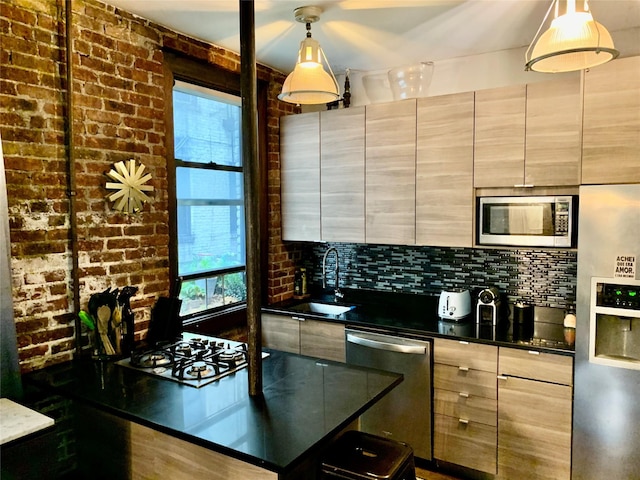 kitchen with decorative light fixtures, stainless steel appliances, tasteful backsplash, and sink