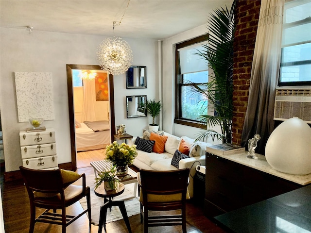 living area with hardwood / wood-style flooring, cooling unit, and an inviting chandelier