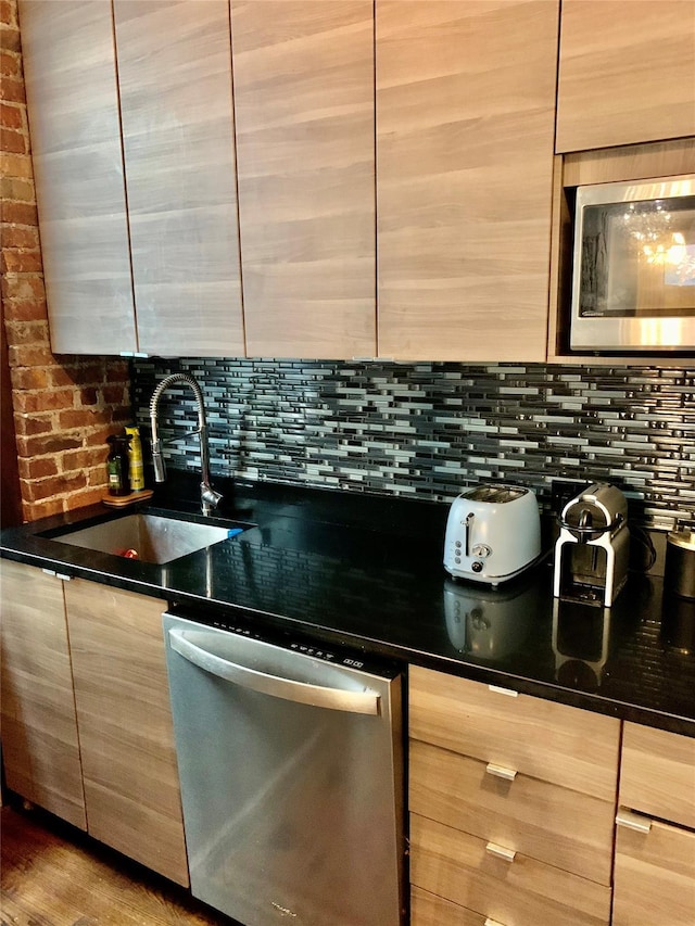 kitchen featuring sink, light brown cabinets, stainless steel appliances, dark stone countertops, and decorative backsplash