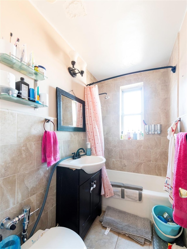 full bathroom featuring tile patterned flooring, toilet, shower / bath combination with curtain, tile walls, and vanity