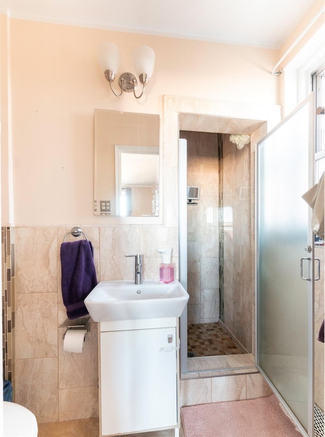 bathroom featuring toilet, tile walls, vanity, and an enclosed shower