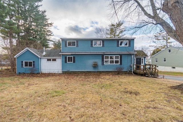 rear view of house featuring a wooden deck and a yard