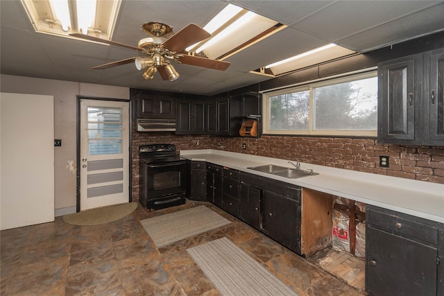 kitchen featuring ceiling fan, sink, brick wall, and black range with electric cooktop