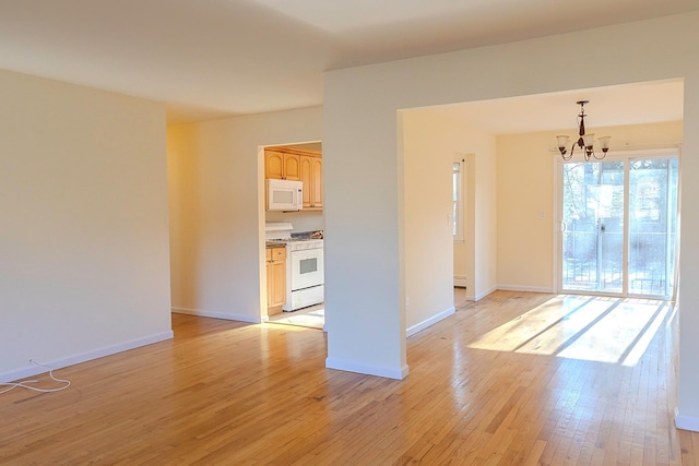 unfurnished room with light hardwood / wood-style floors and a chandelier