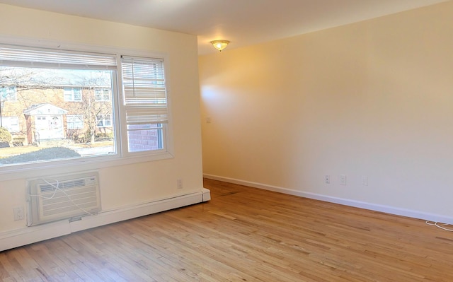 unfurnished room with baseboard heating, light wood-type flooring, and a wall unit AC