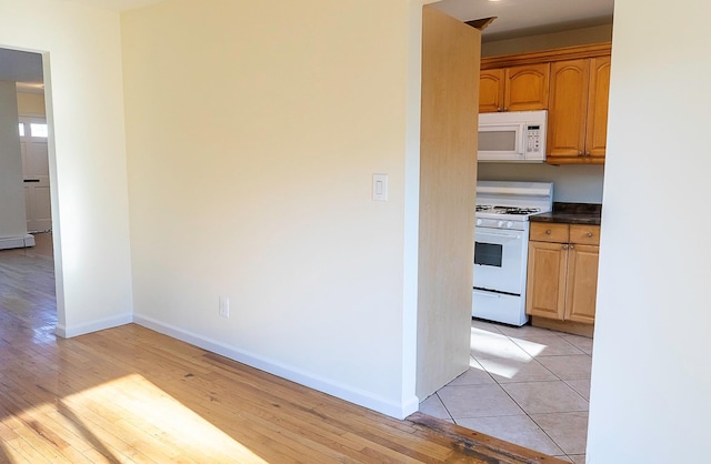 kitchen featuring white appliances and light tile patterned flooring