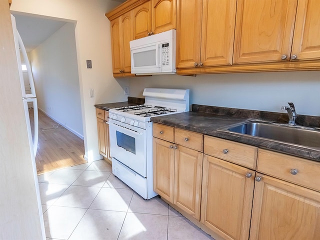 kitchen featuring light tile patterned floors, sink, and white appliances