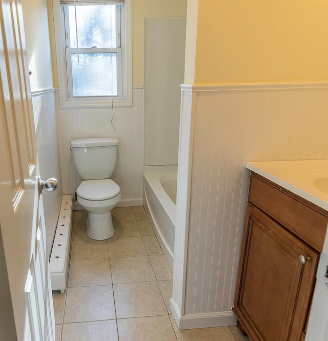 bathroom with toilet, a bathing tub, tile patterned flooring, and vanity